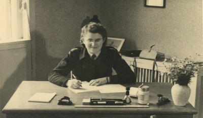 854821 Portret van Marie-Louise Jentjens (1919-2007) in uniform van het Commissariaat Noodvoorziening (C.N.V.), achter ...